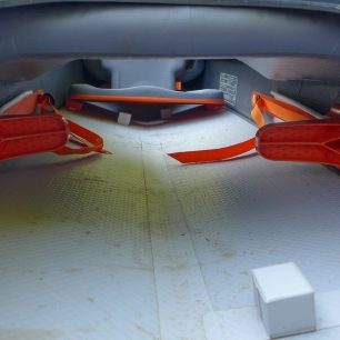 Na fotce je vidět uložení nožních opěrek, usazení a podpěry sedačky a také rozpěrný drop-stitch díl pod palubou mezi háčkem a zadákem