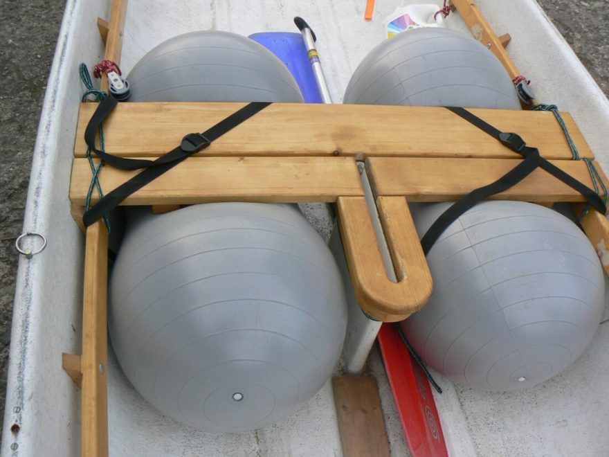 Zabezpečení lodi proti potopení umístěním gymnastických míčů pod prostřední lavičku.