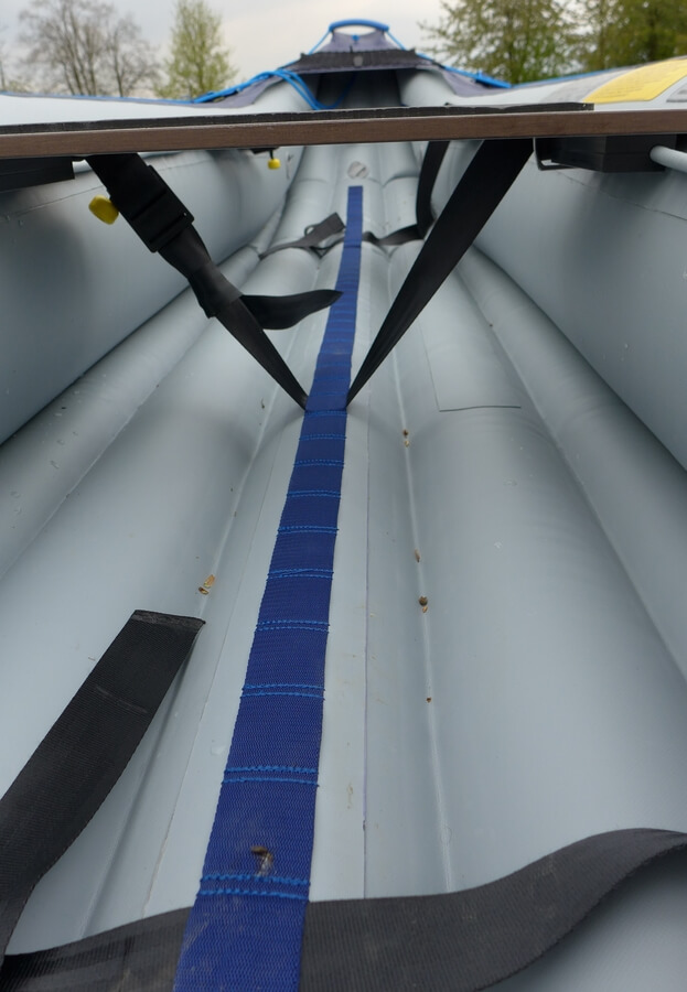 Plochý popruh s oky je vedený po celé délce kánoe.