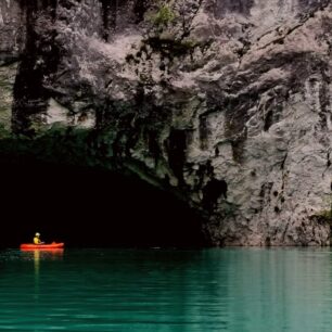 Veliká jeskyně hloboko v kaňonu řeky.