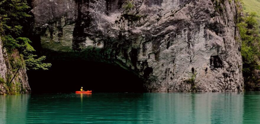 Veliká jeskyně hloboko v kaňonu řeky.