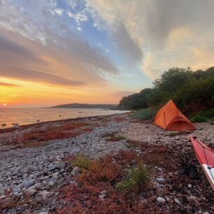 Romantická pláž s flekem na písku a s potůčkem za zády.