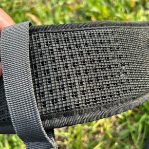 Pogumovaná síťka na spodní straně zádových popruhů a pod ní perforované polstrování.