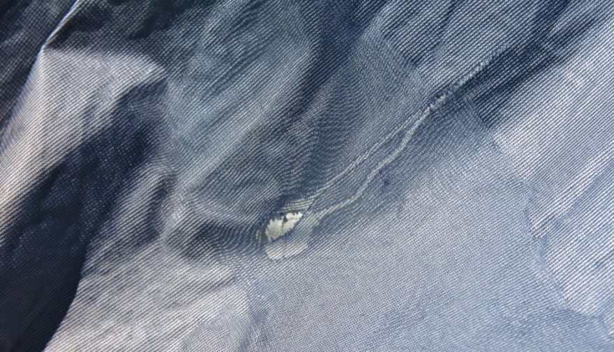 Poškozená vnitřní vrstva membránového materiálu. Od místa poškození se vrstva dál odděluje.