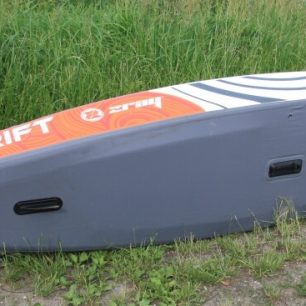 Dno kajaku je tvořeno šedým materiálem, na kterém jsou upevněny dvě pevné flosny a slot pro třetí flosnu