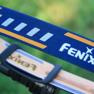 Z vnější strany popruhu najdeme reflexní prvky (bílé obdélníky mezi nápisy Fenix)