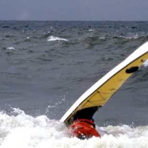 Standa dělá trik v listopadovém surfu na Agawa Beach, Lake Superior Provincial Park, Ontario