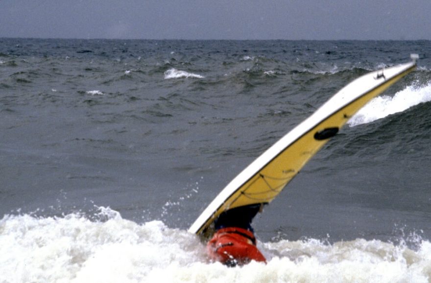 Standa dělá trik v listopadovém surfu na Agawa Beach, Lake Superior Provincial Park, Ontario